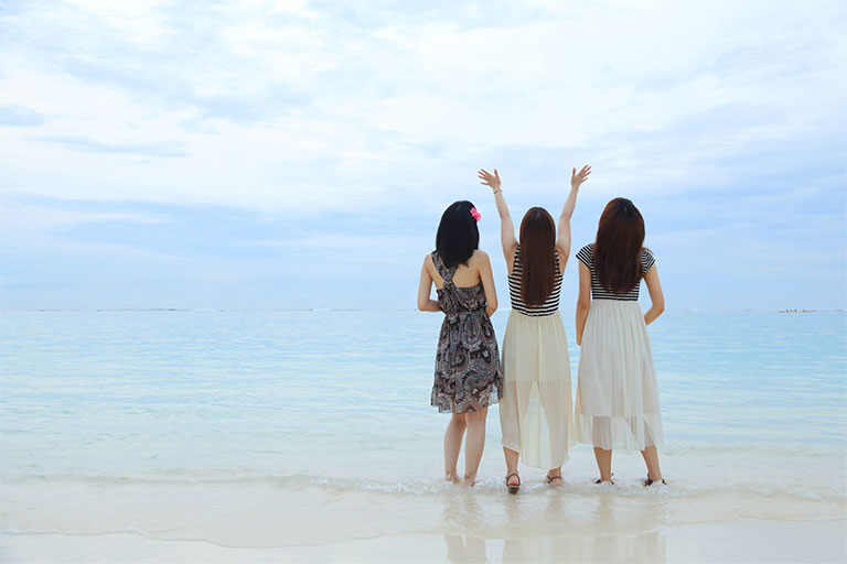 女性３人組と背景にビーチ